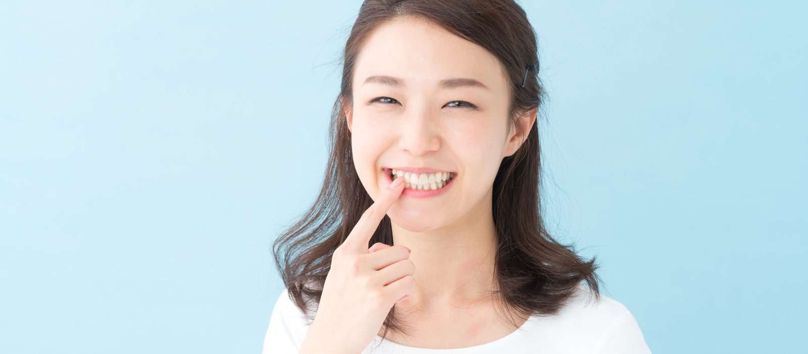 口元に手を添えて微笑む女性